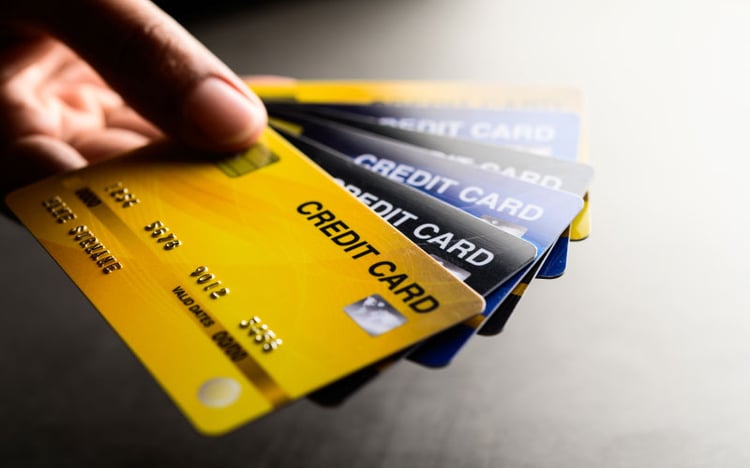 Credit cards of different colors are hold in a hand