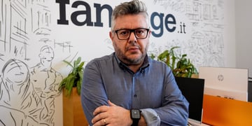 man in dark blue shirt, black watch on right hand, glasses, arms crossed, grey hair