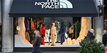 the north face shop window with winter clothing and pedestrians walking by