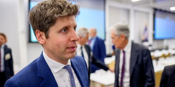 Man in blue suit, white shirt, blue tie, round eyes, big nose