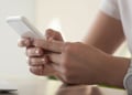 Hands are holding the mobile phone while typing a message
